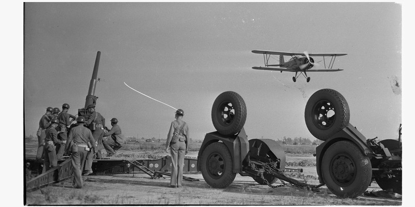 Observation squadron aims anti-aircraft gun at a Douglas plane during a military show for National Defense Week, Los Angeles, 1940. Photo Credit: Los Angeles Daily News Negatives. Department of Special Collections, Charles E. Young Research Library, University of California at Los Angeles.