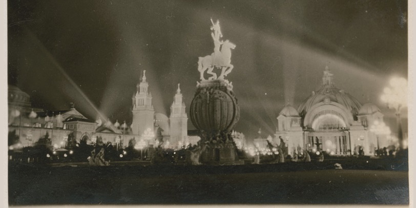 The Fountain of Energy featuring a horse and rider statue above the world is seen at night.