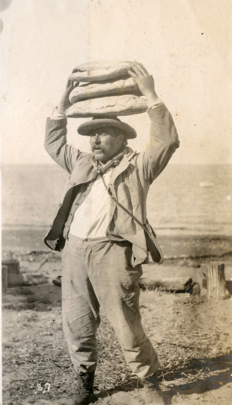 Image is part of a series called Santa Cruz Island Winery, this image shows a man balancing 3 loaves of bread on his head