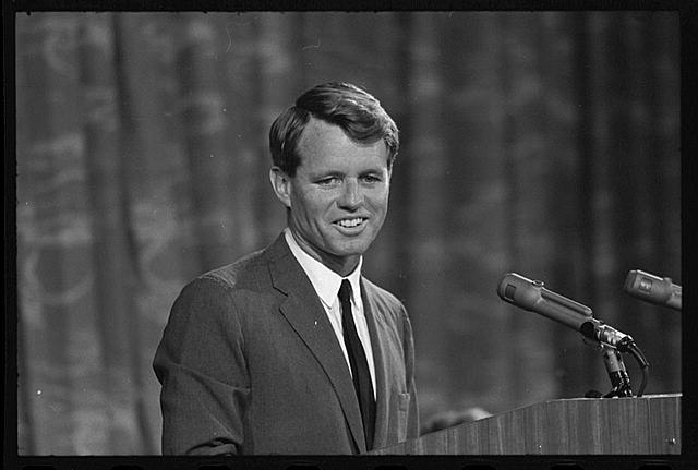 Shows Robert F. Kennedy in front of a lectern