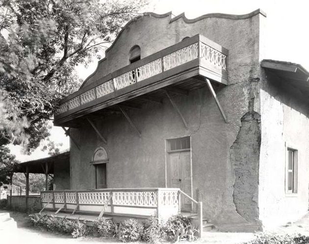 Front of adobe house with pieces of adobe missing