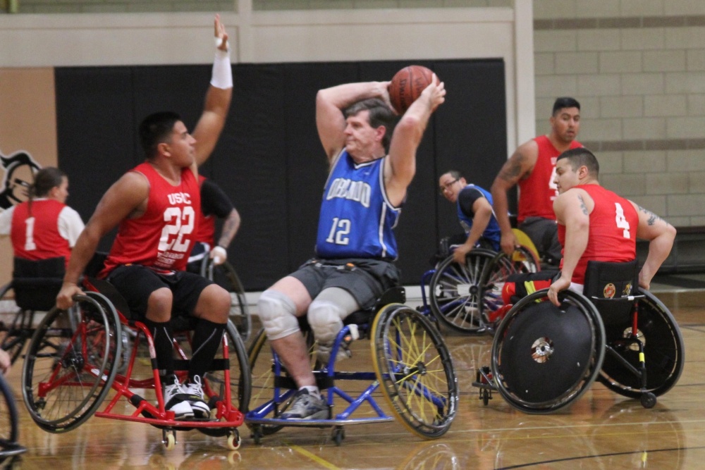 Sgt. Rafael Cervantes from Detachment Hawaii (left) guards a member of the Orlando Magic Wheels during a scrimmage match. The Marines participated in a scrimmage match against the Orlando Magic Wheels, a member of the National Wheelchair Basketball Association. The Marines played in the game as part of the Wounded Warrior Regiment Wheelchair Basketball Camp at the University of Central Florida in Orlando. Marines and Marine veterans participating in the camp will enhance their skills in the areas of passing and shooting, as well as both defensive and offensive techniques. The Warrior Athlete Reconditioning Program (WAR-P) provides activities and opportunities for wounded, ill or injured Marines to train as athletes, while increasing their strength so they can continue with military service or develop healthy habits for life outside the service.